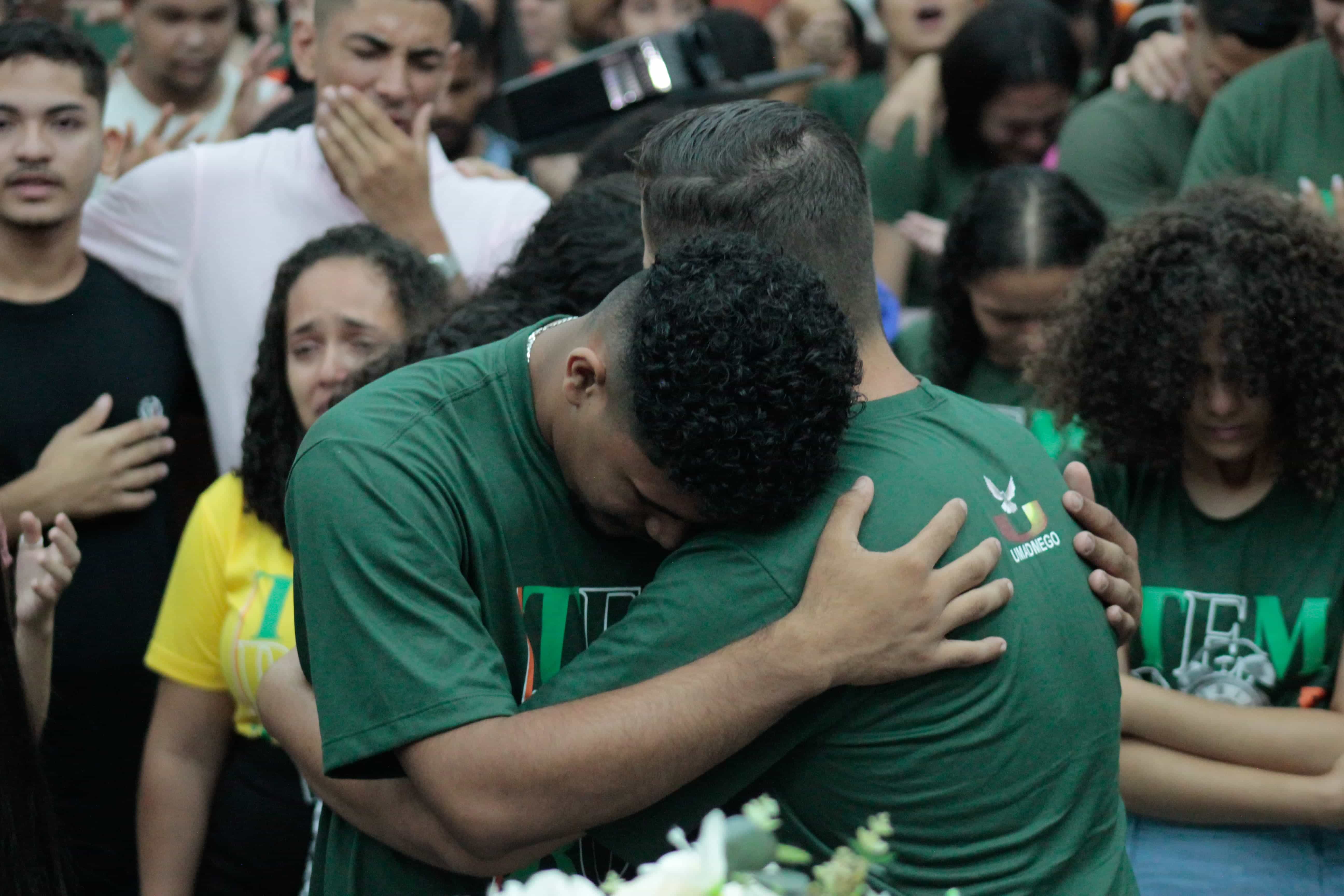 Jovens abraçados durante o culto